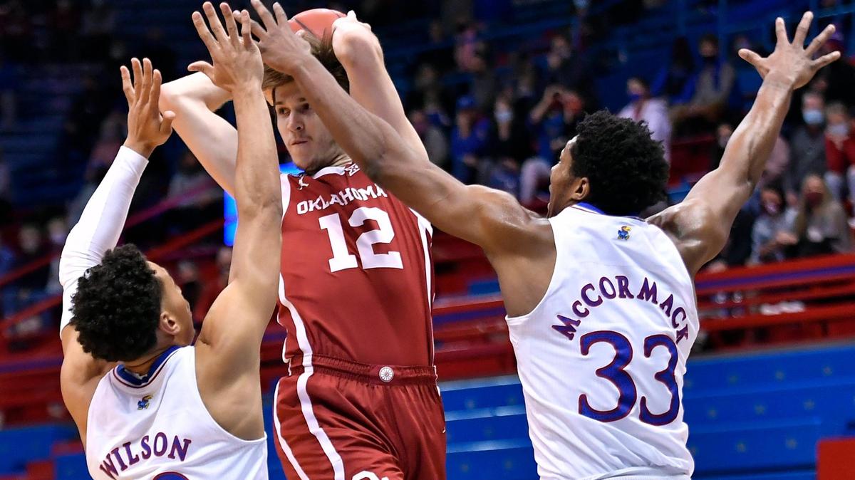 KU’s Jalen Wilson (left) and David McCormack (right) defend OU’s Austin Reaves during Saturday’s Big 12 Conference game at Allen Fieldhouse on Jan. 9, 2021.