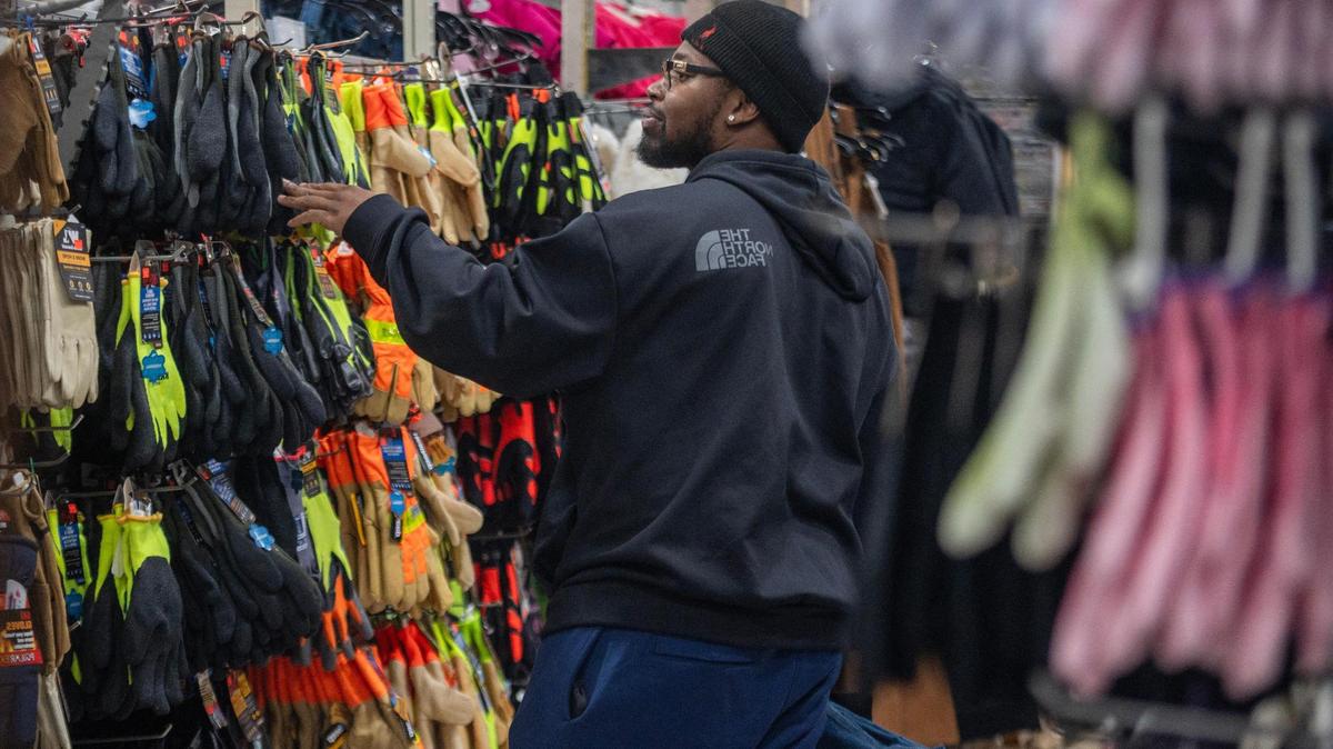 A customer looks at gloves while shopping at Mickey’s Surplus Store on Thursday in Kansas City, Kansas.