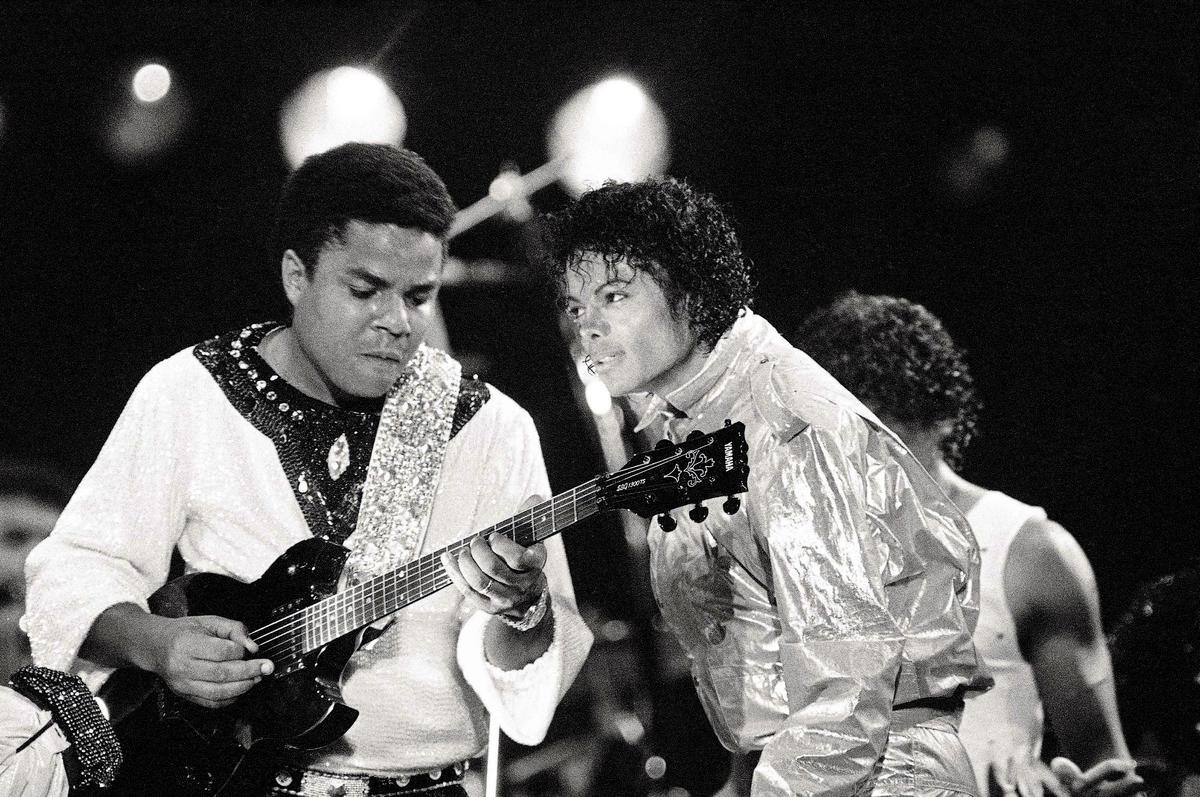 As Tito Jackson, left, plays the guitar, his brother Michael Jackson gives him the eye as part of their performance Friday, July 7, 1984, at Arrowhead Stadium. Two more concerts were held there before moving on to Dallas the following weekend.
