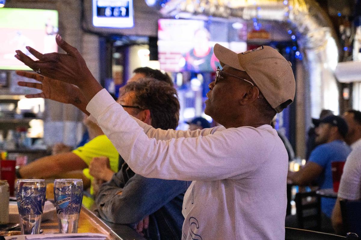 Queen Sheeba gestures at the television as she watches the Royals face off vs. the Baltimore Orioles at the Blue Line in the River Market on Wednesday, Oct. 2, 2024. The Royals won the game 2-1 and advanced to play the New York Yankees.