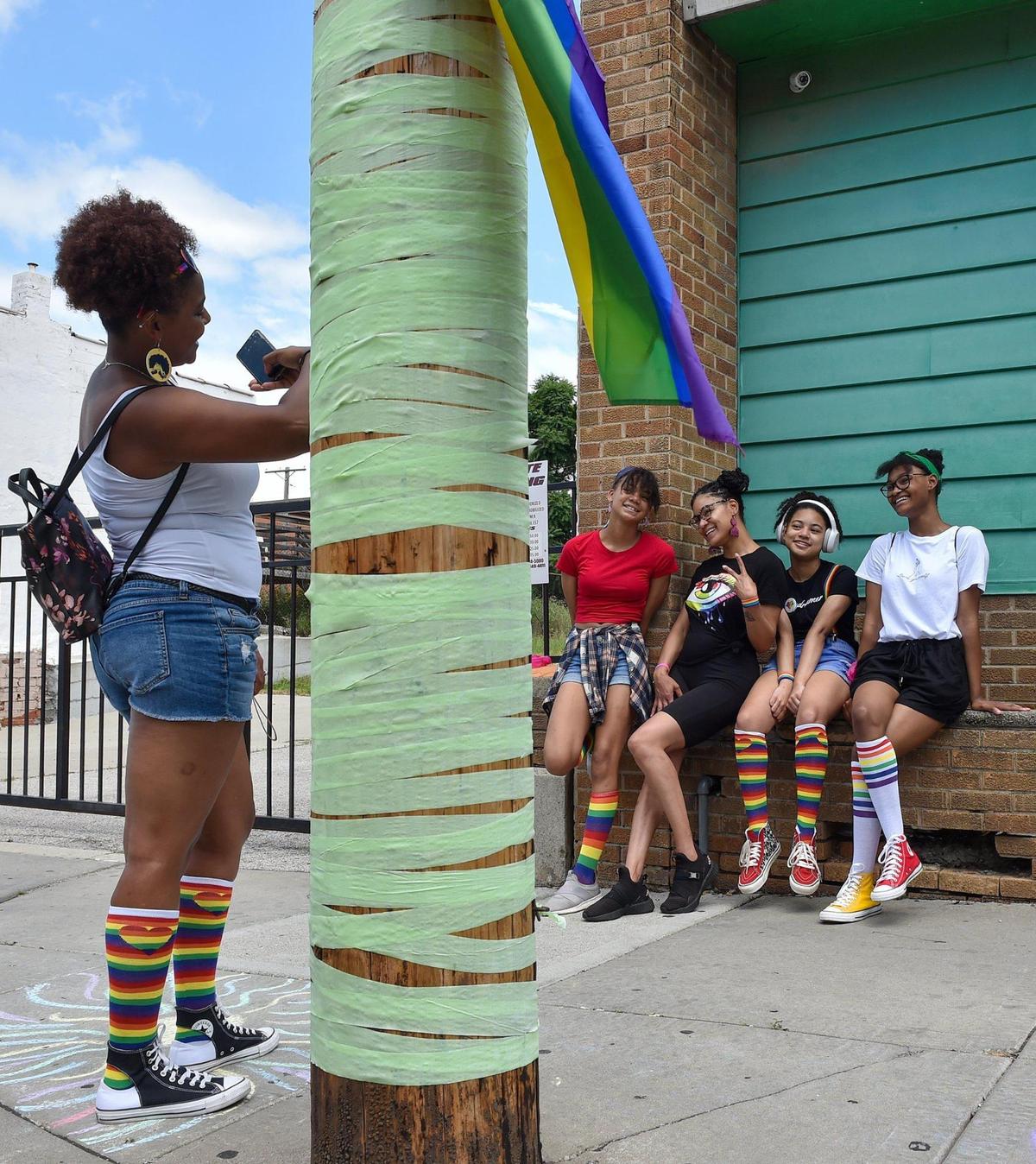 Tiffany Hairston of Kansas City, Kansas, from lett, takes a photo of members of her family including niece Skye Dyer; sister Ashleigh Hairston; niece Auriana Dyer and daughter Saniya Hariston at the first Pride on the Vine 2021 at the 18th and Vine Jazz District Saturday, June 26, 2021. They wore rainbow socks and came to the event to support Auriana, center, who came out as pansexual in the seventh grade. It’s Auriana’s first pride event.