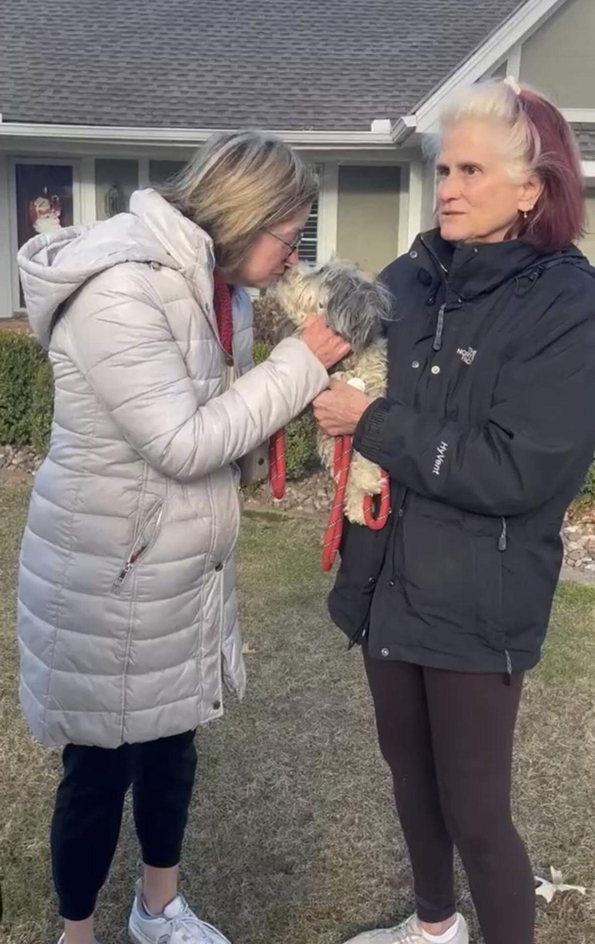 Julie Hirons, left, reunites with her lost dog, Gracie, after Karen Gortenburg from Kansas City Dog Trappers coaxed the pup out of a Leawood backyard.