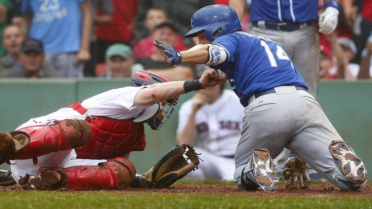 Boston Red Sox catcher Ryan Hanigan reaches up to tag out Kansas City Royals' Omar Infante (14) after he tried to stretch a triple into an inside the park home run during the ninth inning of Kansas City's 8-6 win in a baseball game at Fenway Park in Boston, Sunday, Aug. 23, 2015. 
