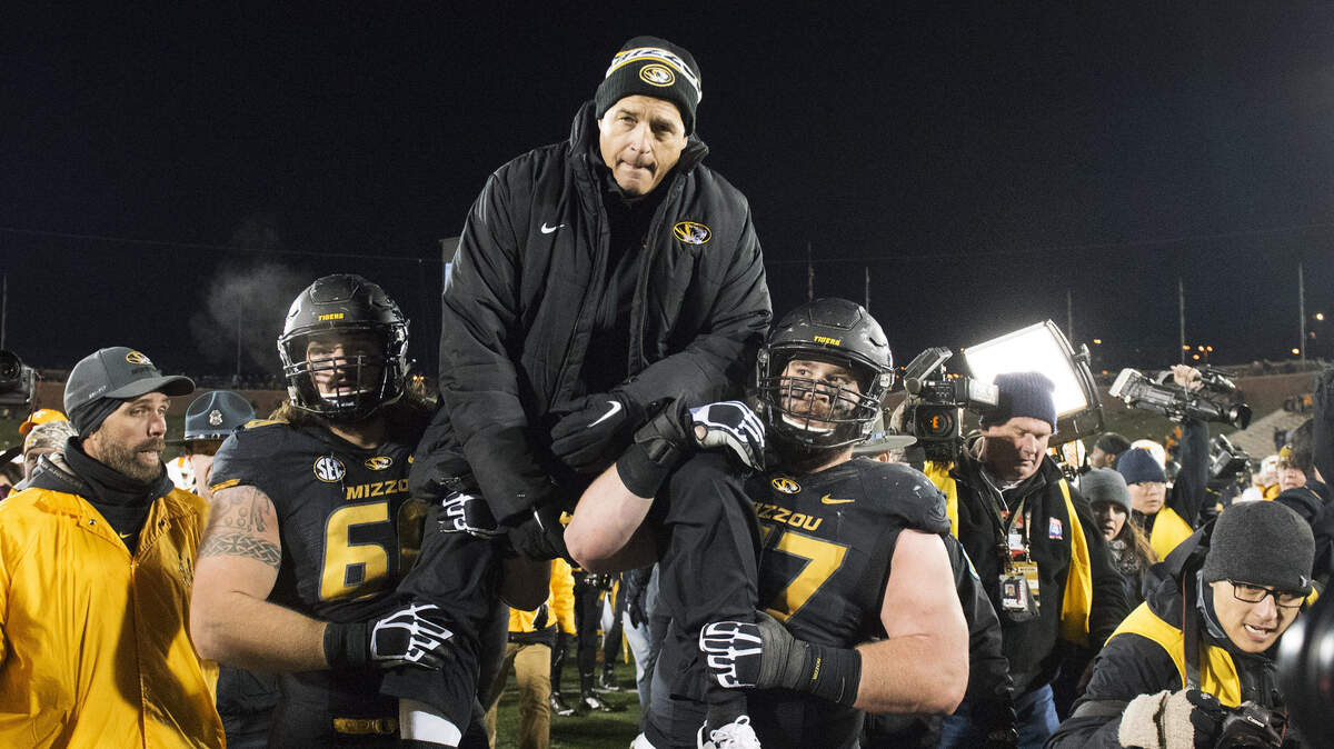 Missouri head coach Gary Pinkel, center, is carried off the field by players Evan Boehm, right, and Connor McGovern, left, after an NCAA college football game against Tennessee, Saturday, Nov. 21, 2015, in Columbia, Mo., the final home game for Pinkel as head coach of Missouri. (AP Photo/L.G. Patterson)