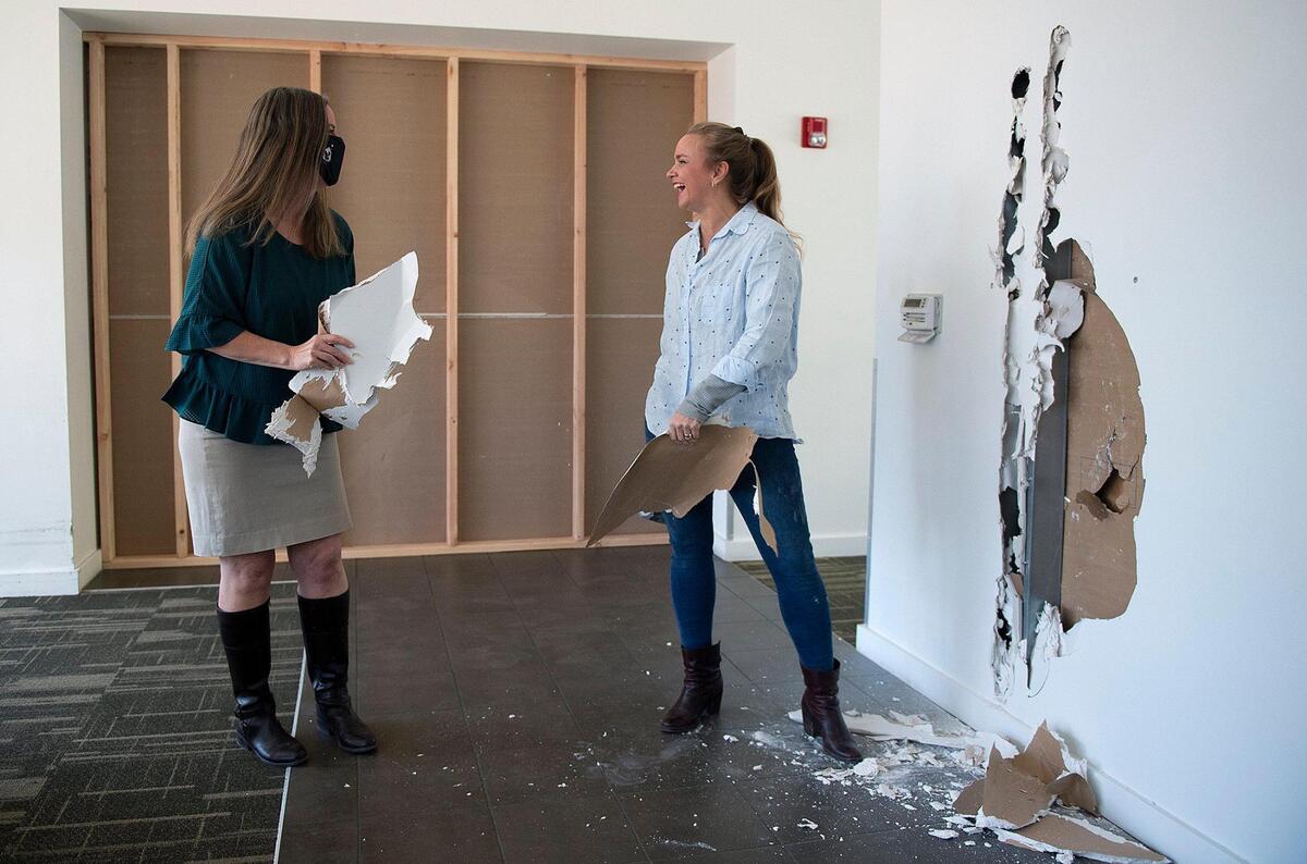 Tami Greenberg, left, CEO of Ronald McDonald Charities Kansas City, shared a laugh with Tamara Day of HGTV’s “Bargain Mansions” after Day used a sledgehammer to punch into wall Thursday at the charities’ Longfellow House. 