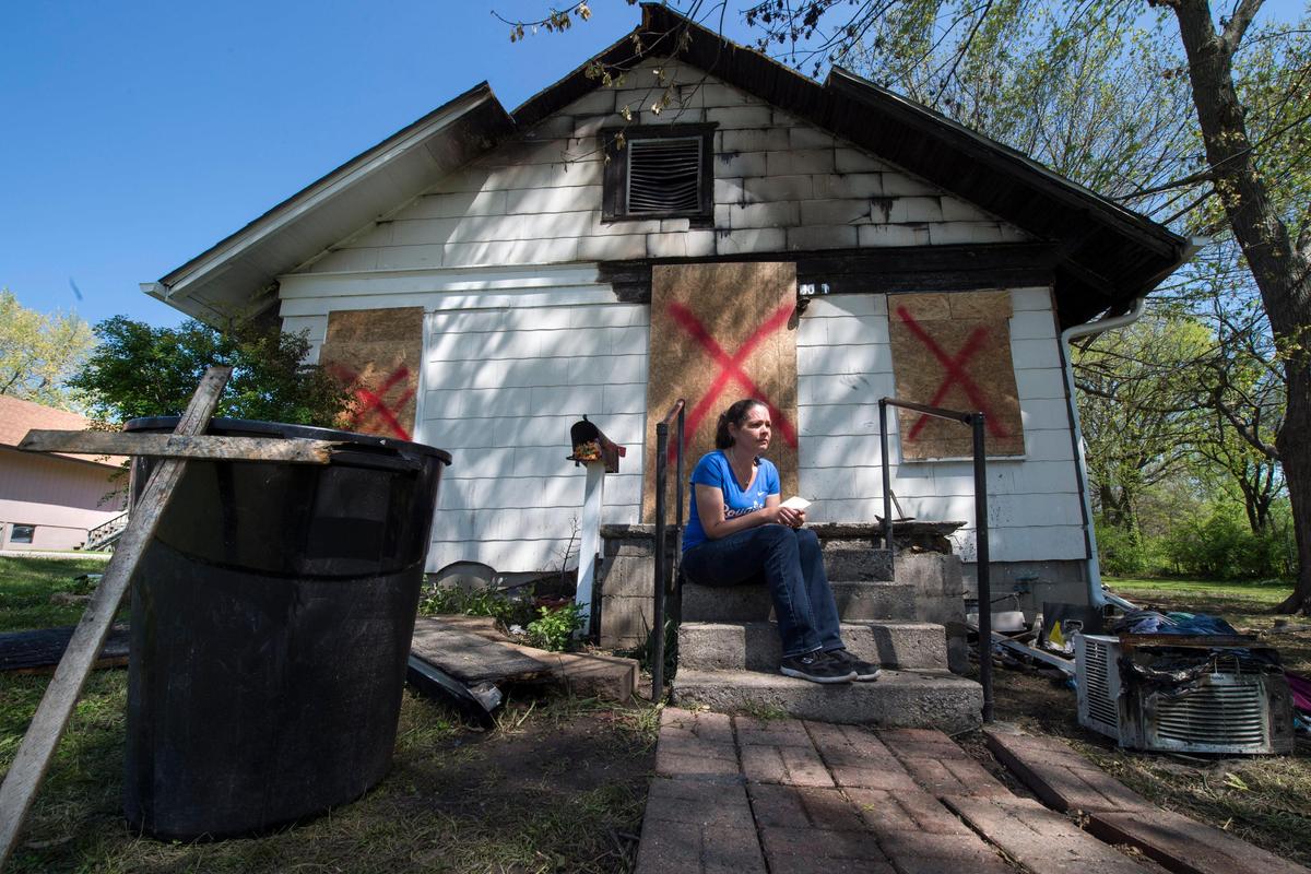 Clutching her fathers’ discharge papers, Carmen Forbes of Glasgow, Missouri, sits on the front steps of the home where her father, James “Dean” Masters, a Vietnam veteran, died in a fire Tuesday, April 21, 2020, on South Benton Avenue in Kansas City. On Thursday, Forbes said Masters, who was known to help the less fortunate, gave his last breath shielding a homeless woman, who was staying temporarily with Masters, from the fire.
