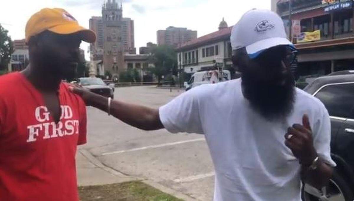 Derrick Kindle rests his hand on Martin Davis as the two men prayed outside the Country Club Plaza Sunday morning. Neither participated in the protests. “Where are our leaders,” the both asked aloud.
