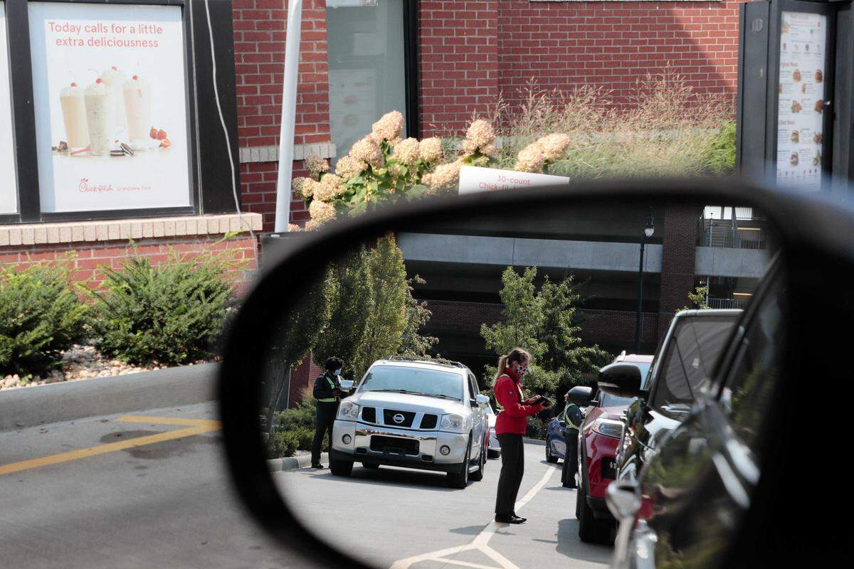 Employees take orders as drivers wait in the Chick-fil-A drive-thru on Tuesday in Grandview Heights. The ongoing COVID-19 pandemic has caused increases for wait times at fast-food restaurants, and Chick-Fil-A has one of the longest wait times in the country, but also scores high on customer satisfaction.