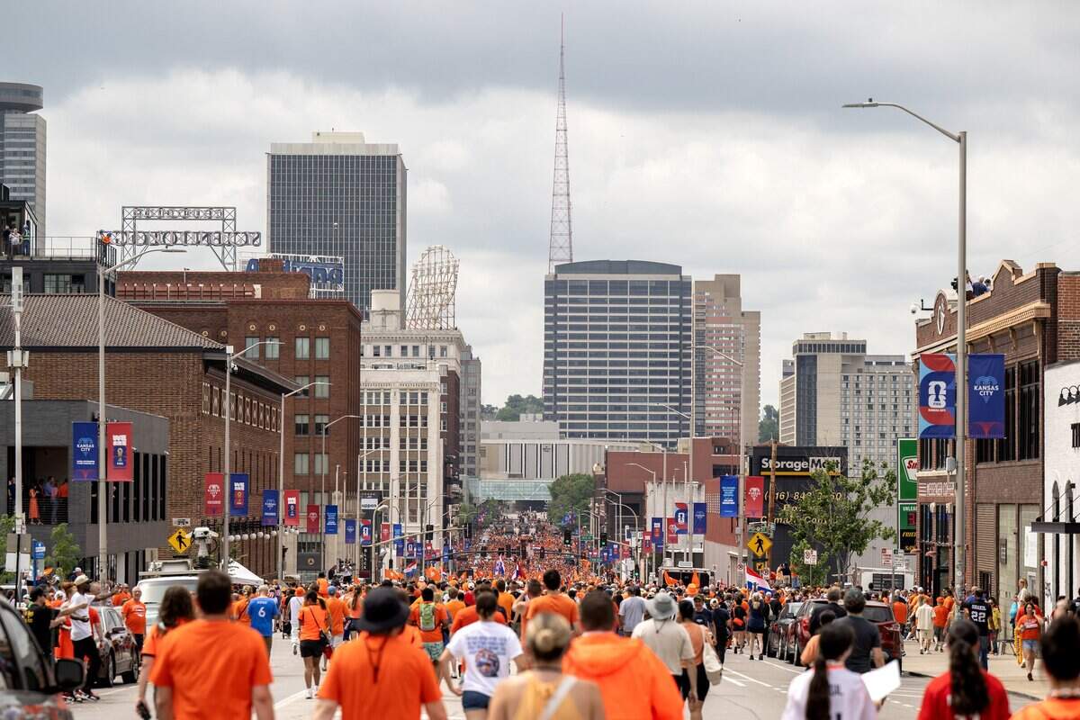 Fans walk down Grand Boulevard as they celebrate during the Orange Walk on Thursday, June 25, 2026, in Kansas City.