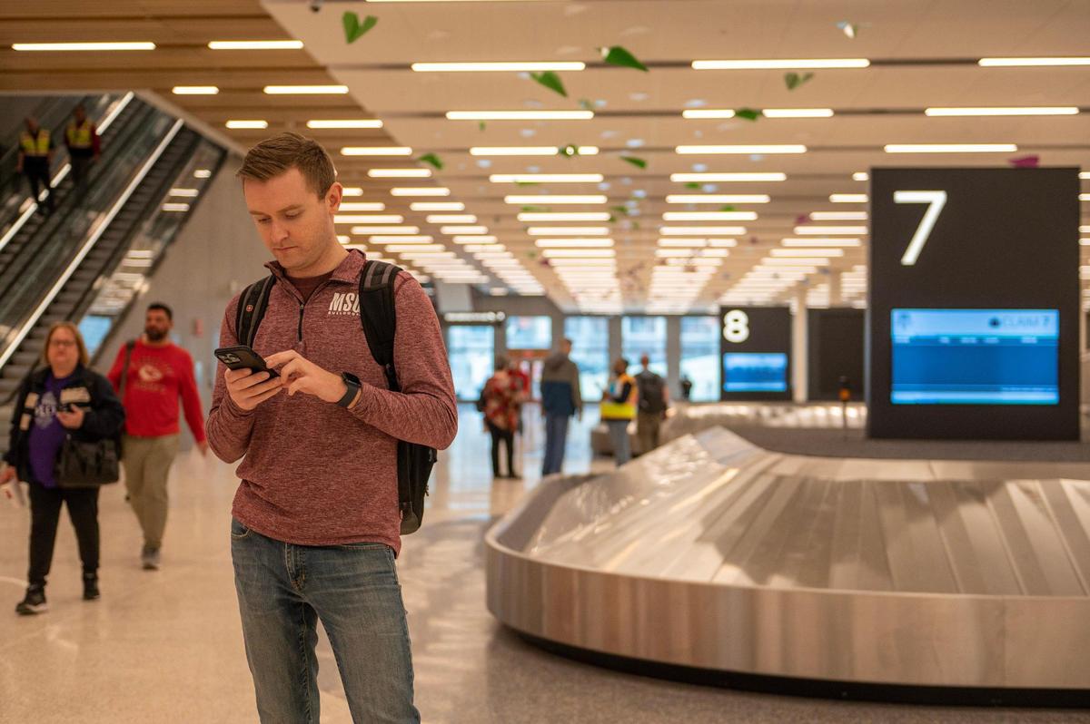 Jacob Lanier, a Southwest International test passenger, picks up his baggage at baggage claim during a simulation tour of the new single terminal Tuesday at Kansas City International Airport.