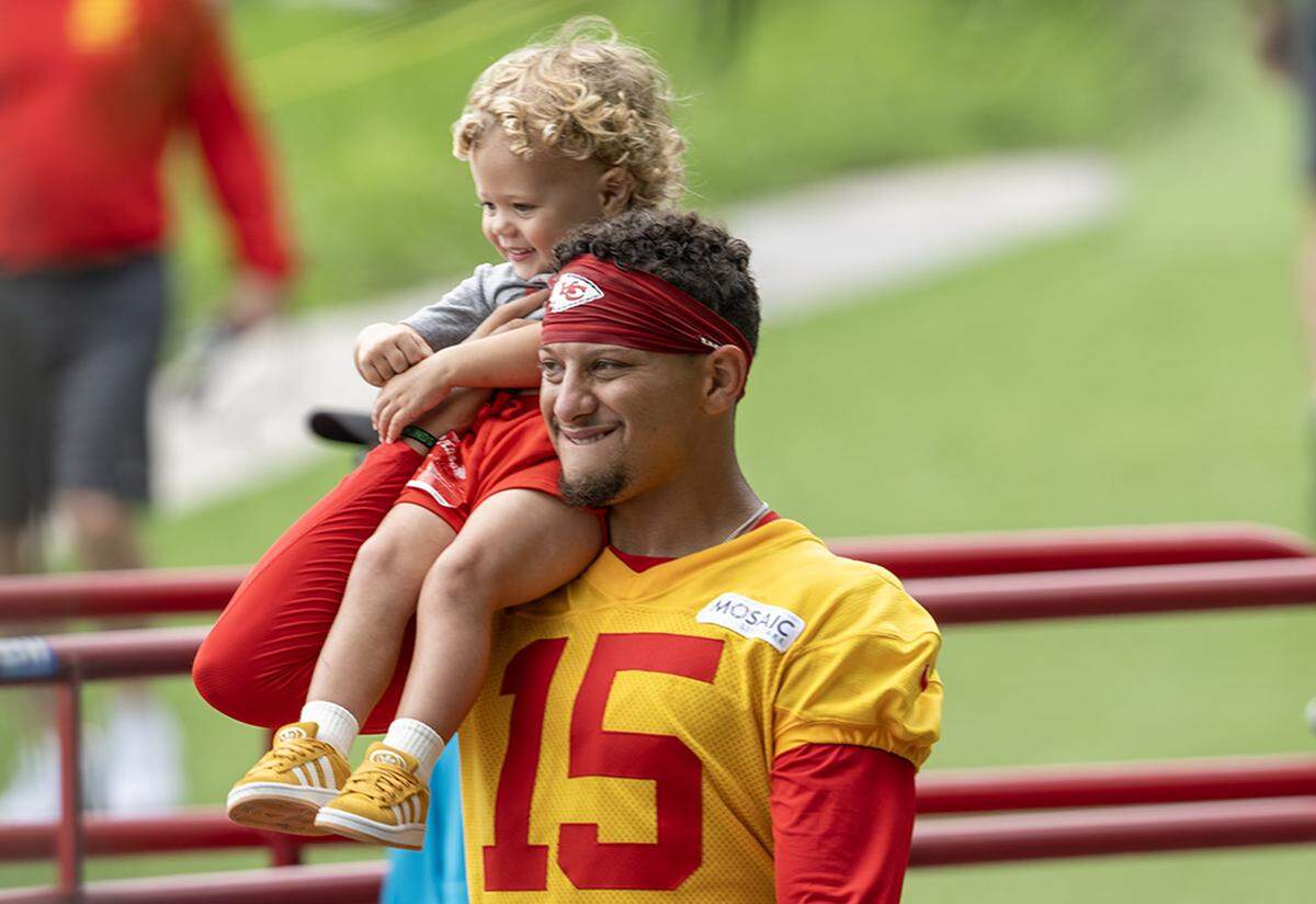 Kansas City Chiefs quarterback Patrick Mahomes (15) carries his son, Patrick "Bronze" Lavon Mahomes III at training camp at Missouri Western State University on Wednesday, July 30, 2025, in St. Joseph, Missouri.