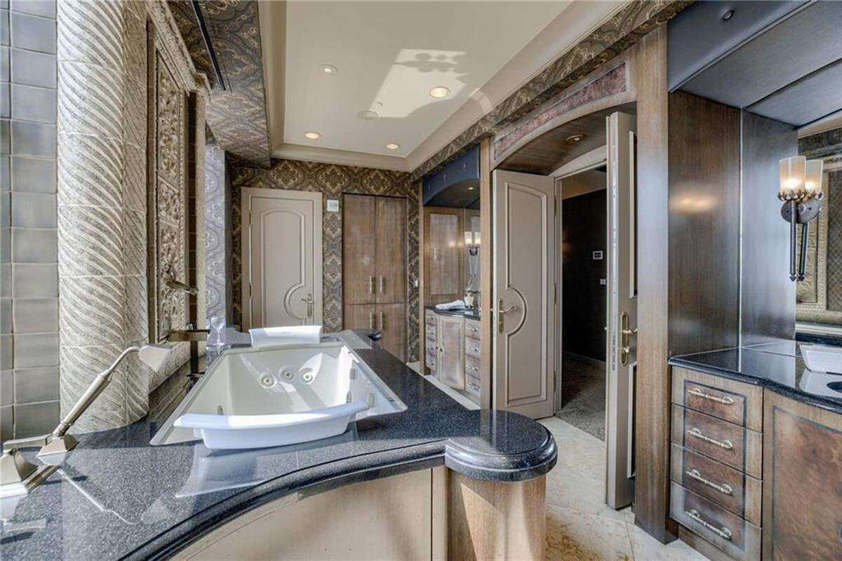 The master suite bathroom inside the condo at 909 Walnut St. includes custom cabinetry, stonework, a walk-in shower and a whirlpool tub.