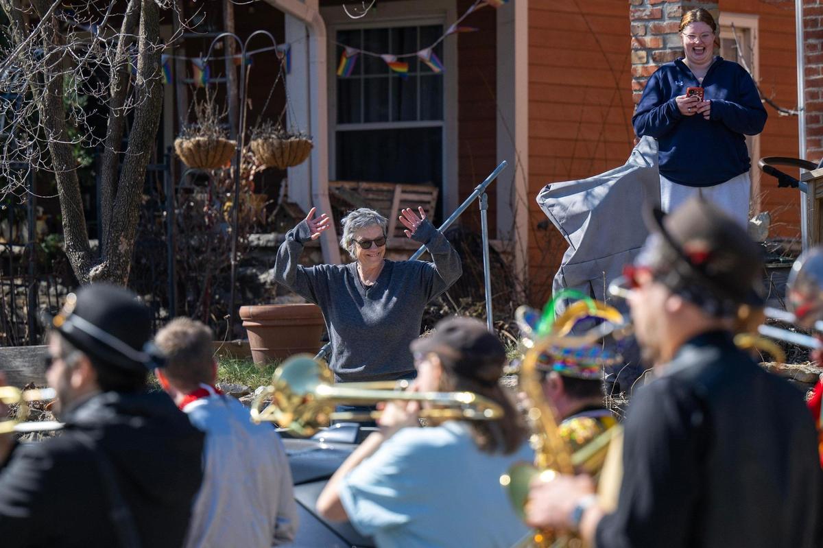 Neighbors wave and smile as the Krewe de Prank parade passes down Summit Street on Sunday, March 2, 2025, in Kansas City.