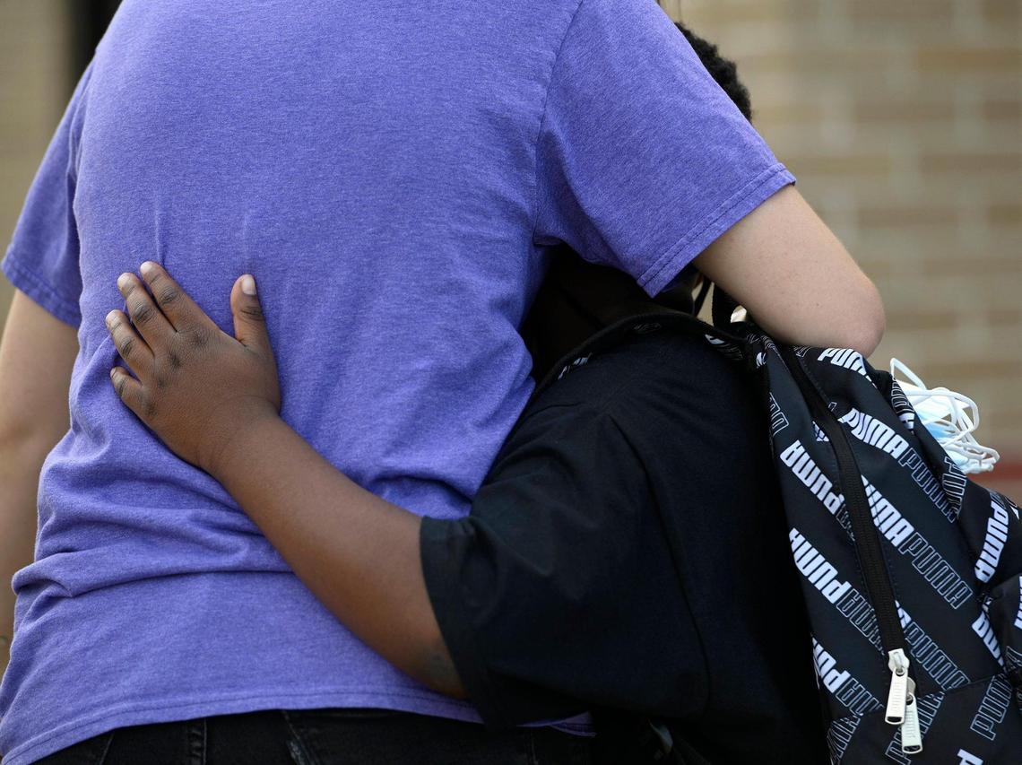 A student hugs a teacher on the first day of school at Hazel Grove Elementary School in Kansas City, Kansas. Area teachers say they’ll be working on students’ emotional health as well as classroom instruction.