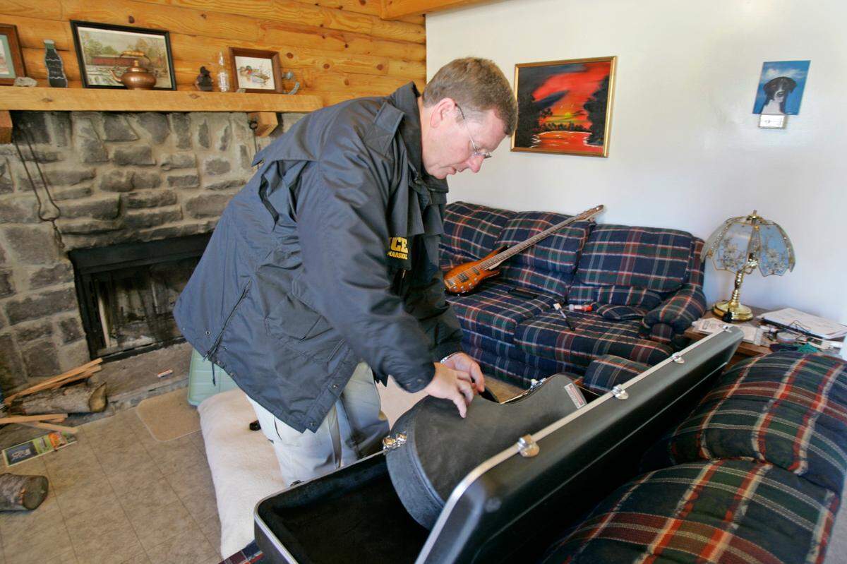 PHOTO BY: ALLISON LONG/KANSAS CITY STAR 022606 022606 U.S. Marshals escorted some members of the media around the cabin in Alpine , Tenn., were Toby Young and John Manard stayed for 12 days after Young helped Manard escape from prison in Lansing, Kan. U.S. Marshal Denny King showed the guitar and mandoln found in the cabin. cutline: Among the items in the cabin were two new guitars, an amplifier, a mandolin and sheet music. On Sunday, U.S. Marshal Denny King showed the instruments to the media.