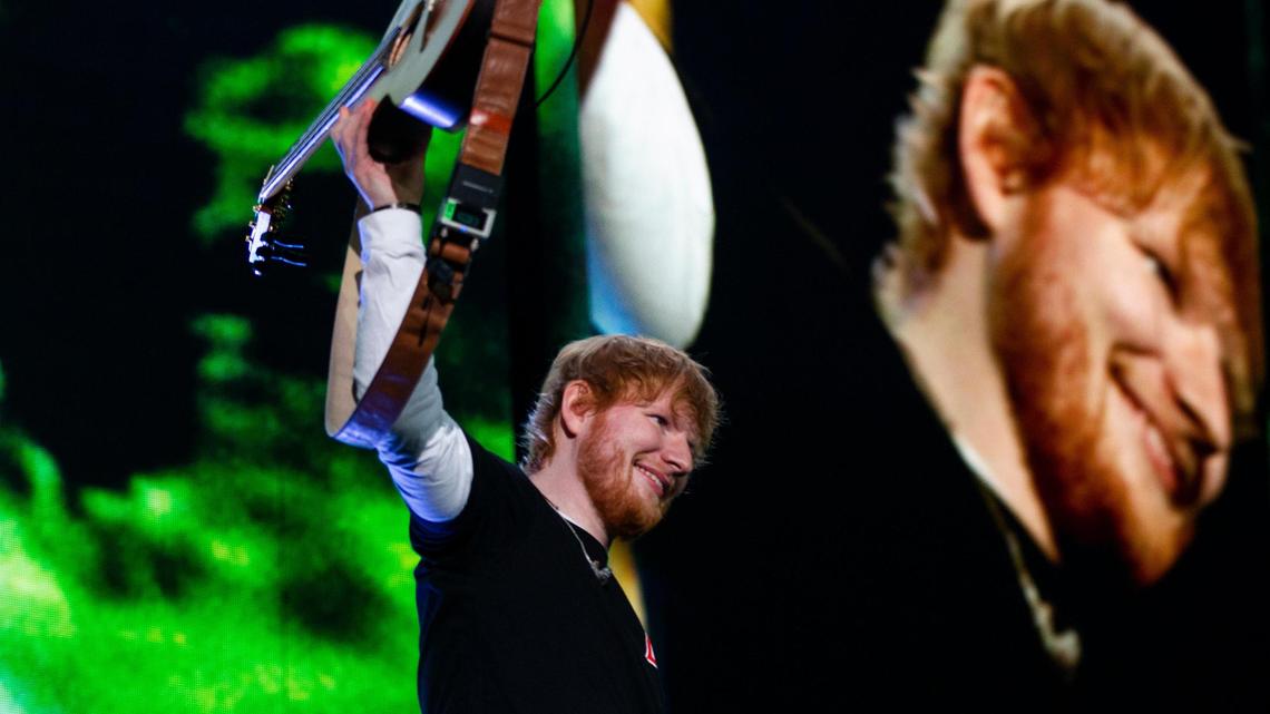 Following “Castle on the Hill,” Ed Sheeran raises his guitar to the crowd at Arrowhead Stadium Saturday night during his Divide Tour stop in Kansas City. Sheeran played in front of a packed house on a chilly night.