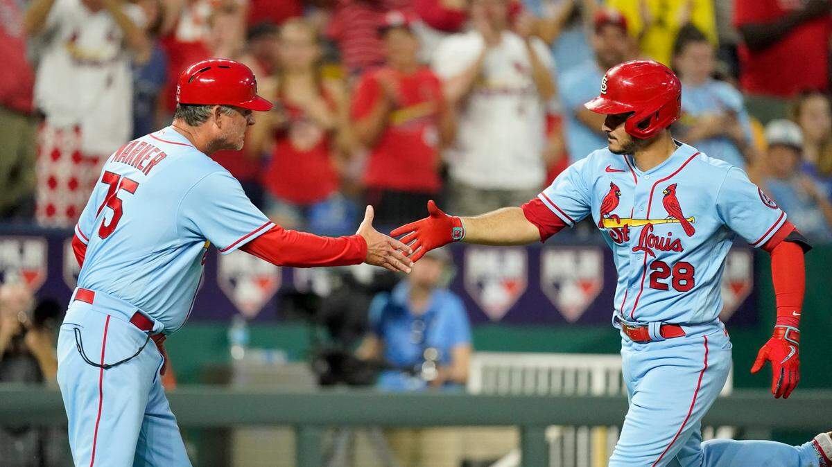 St. Louis Cardinals’ Nolan Arenado (28) celebrates with third base coach Ron ‘’Pop’’ Warner after hitting a two-run home run during the seventh inning of a baseball game against the Kansas City Royals Saturday, Aug. 14, 2021, in Kansas City, Mo. (AP Photo/Charlie Riedel)
