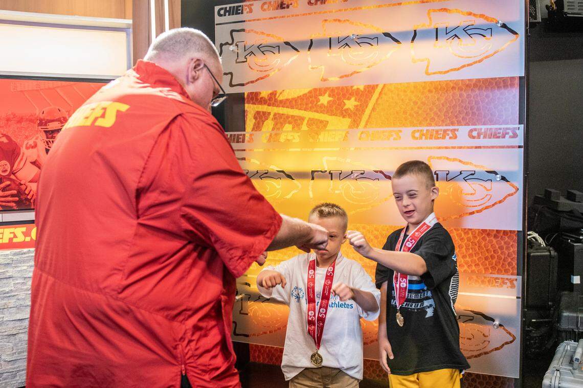 Chiefs coach Andy Reid exchanges fist-bumps with Special Olympians Brooks Meyer and Zachary Pingeton, right.
