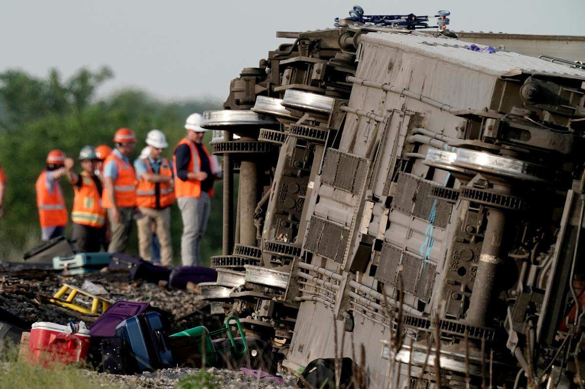 Workers inspected the scene after an Amtrak train derailed after striking a dump truck June 27 near Mendon, Missouri.