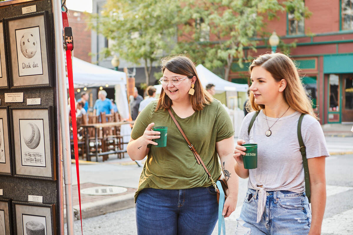 Two women looking at some of the art on display at “Art Westport.” The art fair is back for its 42nd year.
