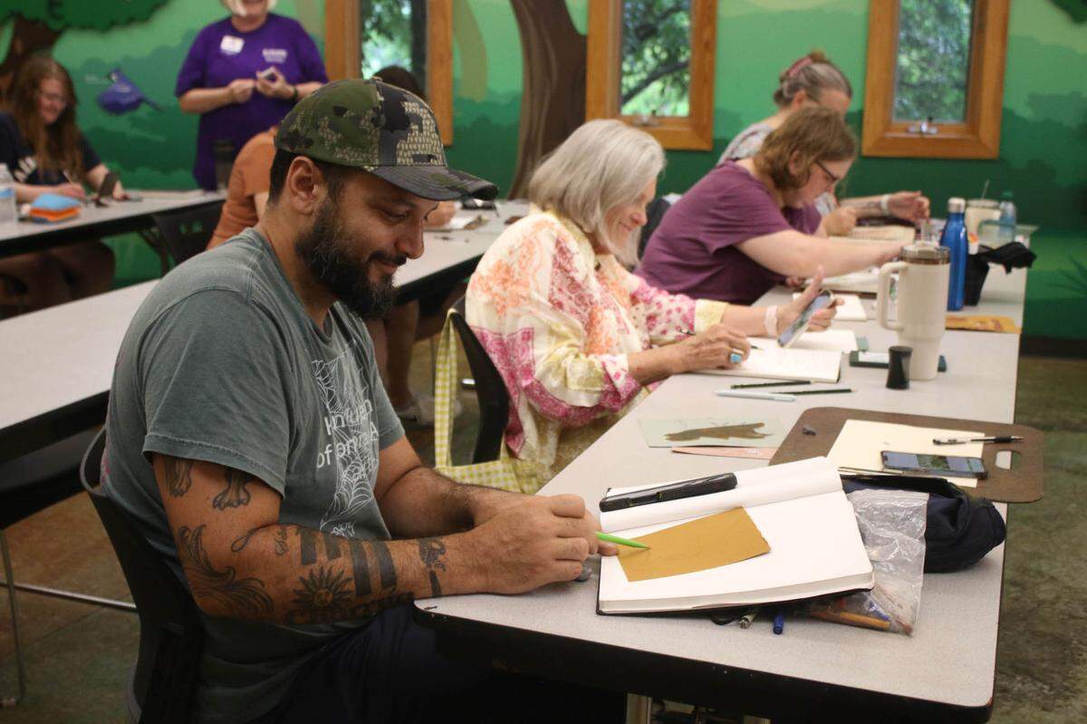 Kansas City, Kansas, resident Rodrigo Alvarez sketches marjoram during the herb drawing class at the Overland Park Arboretum.