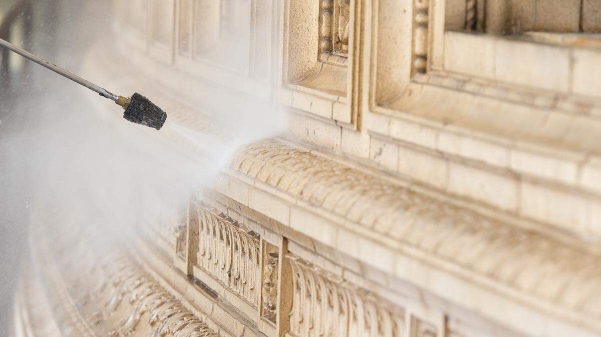 Power washing a building.