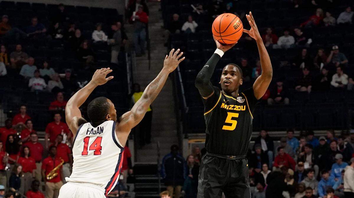 Missouri guard D’Moi Hodge, right, shoots a three-pointer over Mississippi guard Tye Fagan during Tuesday night’s game in Oxford, Miss. Hodge was MU’s leading scorer with 24 points.