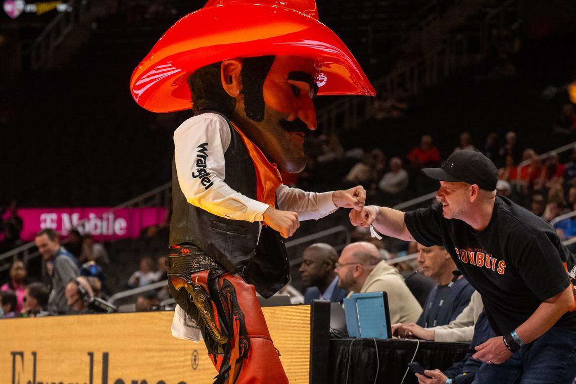 The mascot for the Oklahoma State Cowboys fist bumps a fan courtside in the second half of the Colorado Buffaloes first round game vs. the Oklahoma State Cowboys in the Big 12 Men's Basketball Tournament, on Tuesday, March 10, 2026, at T-Mobile Center.