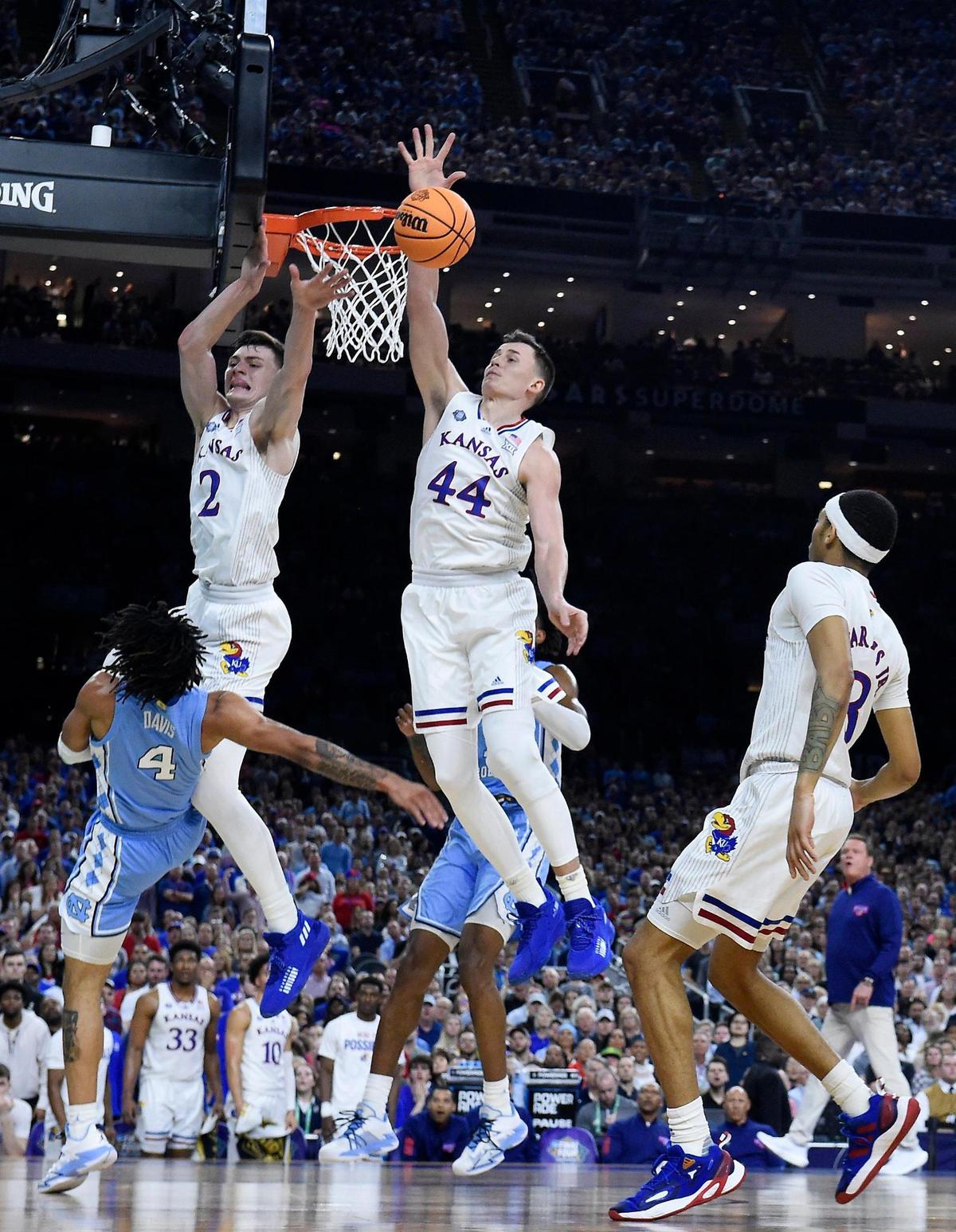 KU’s Christian Braun and Mitch Lightfoot slap down a shot by UNC’s RJ Davis during the first half of Monday night’s NCAA championship game at the Superdome in New Orleans. KU beat North Carolina, 72-69.