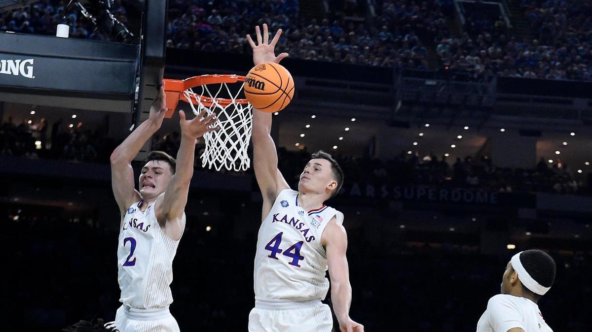 KU’s Christian Braun and Mitch Lightfoot slap down a shot by UNC’s RJ Davis during the first half of Monday night’s NCAA championship game at the Superdome in New Orleans. KU beat North Carolina, 72-69.