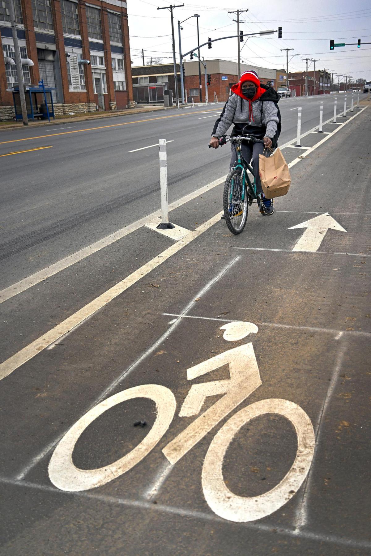Kia Welch rides a bike in the bike lane on the north side of Truman Road on Thursday, March 2, 2023, in Kansas City. Welch said she ‘bikes all the time,” and that the bike lanes along Truman Road are needed. “There’s not a whole lotta buses on this side of town,” said Welch.