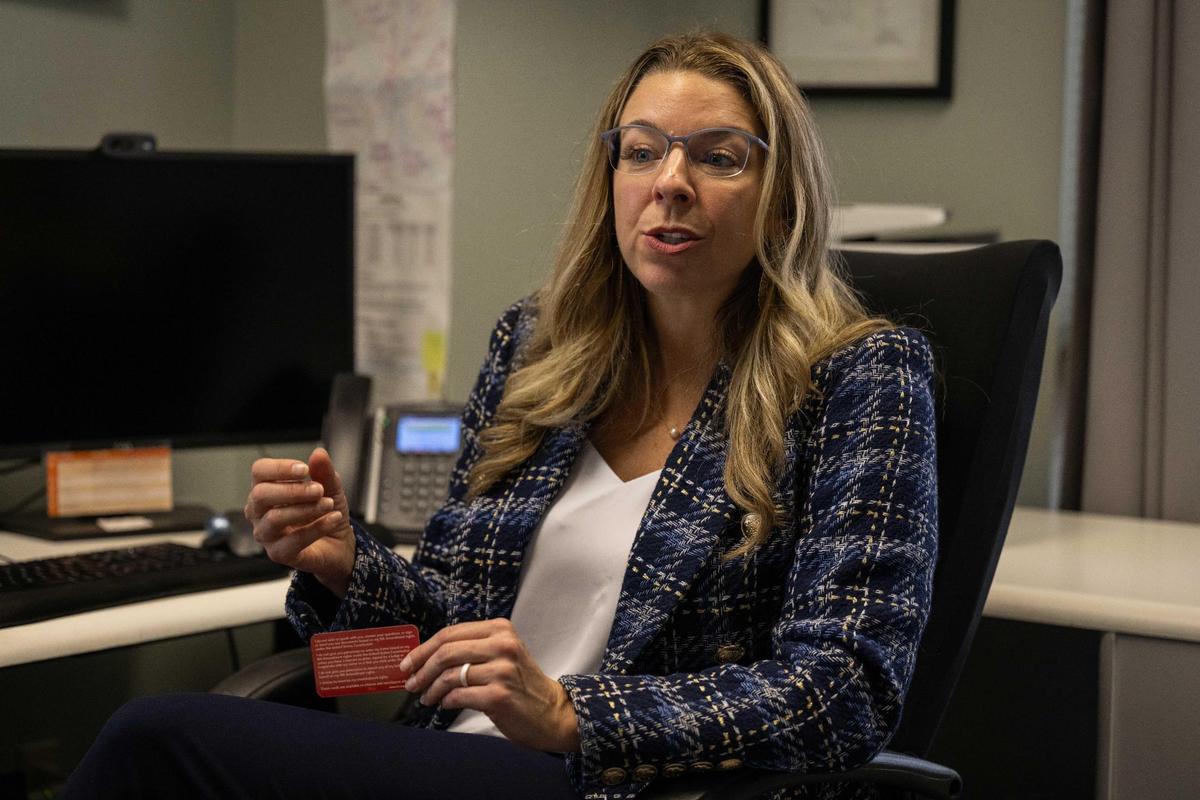 Andrea Martinez, an immigration attorney in Kansas City, holds up a Red Card with printed information for immigrants confronted by Immigration and Customs Enforcement agents.