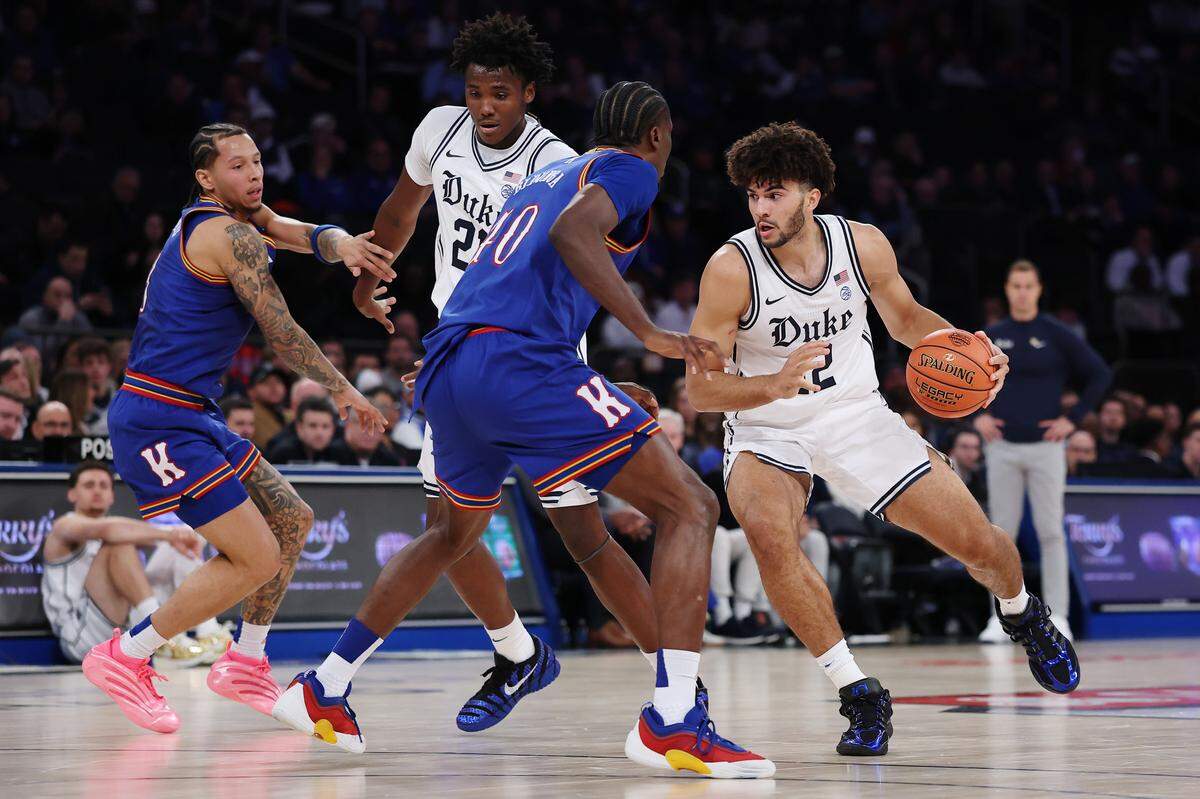 Cameron Boozer #12 of the Duke Blue Devils dribbles against Flory Bidunga #40 of the Kansas Jayhawks during the first half in the 2025 State Farm Champions Classic at Madison Square Garden on November 18, 2025 in New York City.