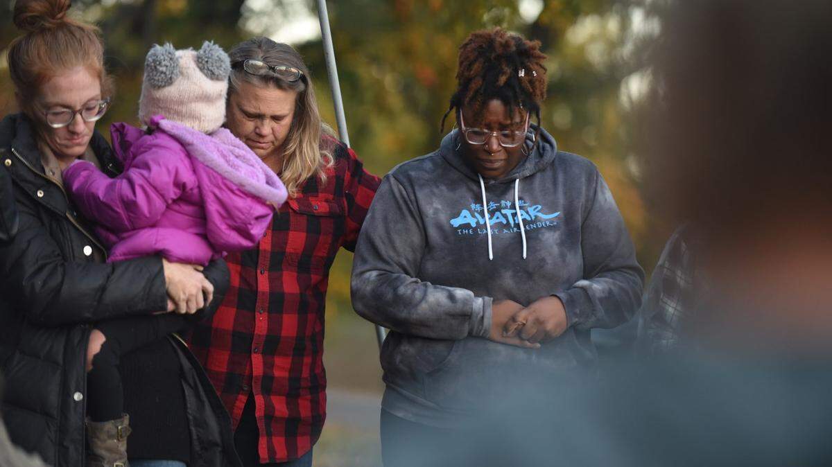 Lori Patton, de 54 años, en el centro, y Yajieraka Chambers, de 29 años, ambas de Excelsior Springs, estaban entre las cerca de tres docenas de personas que se reunieron en Siloam Mountain Park para rezar después de que una mujer escapara de una casa de la localidad donde, según dijo a la policía, había sido secuestrada y maltratada durante un mes.