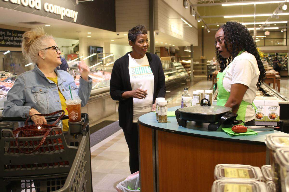 Leawood resident Marianne Brennan chats with Linda Donaldson and Kiley Williams-Bowls at Hen House Market, 11721 W. Roe Ave.