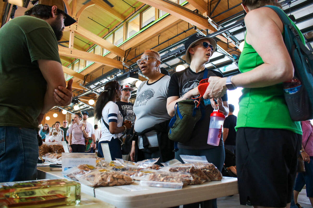 Shoppers talk to workers at Prothe’s Pecans at the Overland Park Farmer’s Market on June 6, 2026.