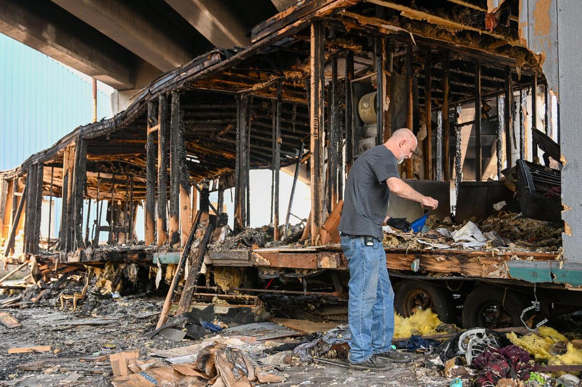 Alan Ashurst, an illegal dumping investigator for Kansas City, looks through paperwork Monday at a mobile home found under the 23rd Street bridge at Manchester Trafficway.