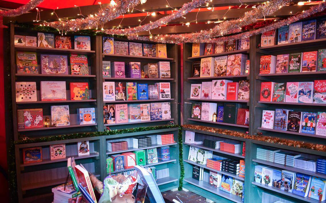 Shelves with a selection of books for sale are set up at Rainy Day Books’ vendor tent inside the free Hallmark Christmas Experience.