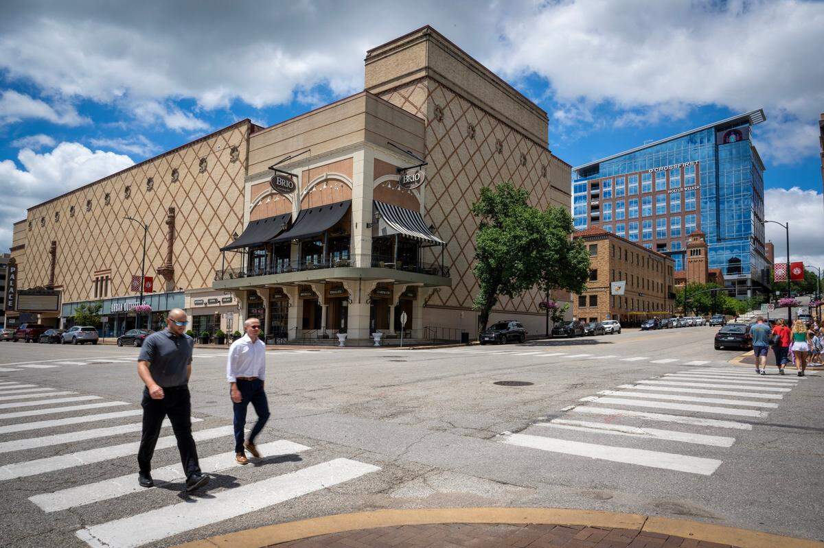 Pedestrians stroll along Nichols Road past Brio Italian Grille in April 2024. The restaurant is now closed.