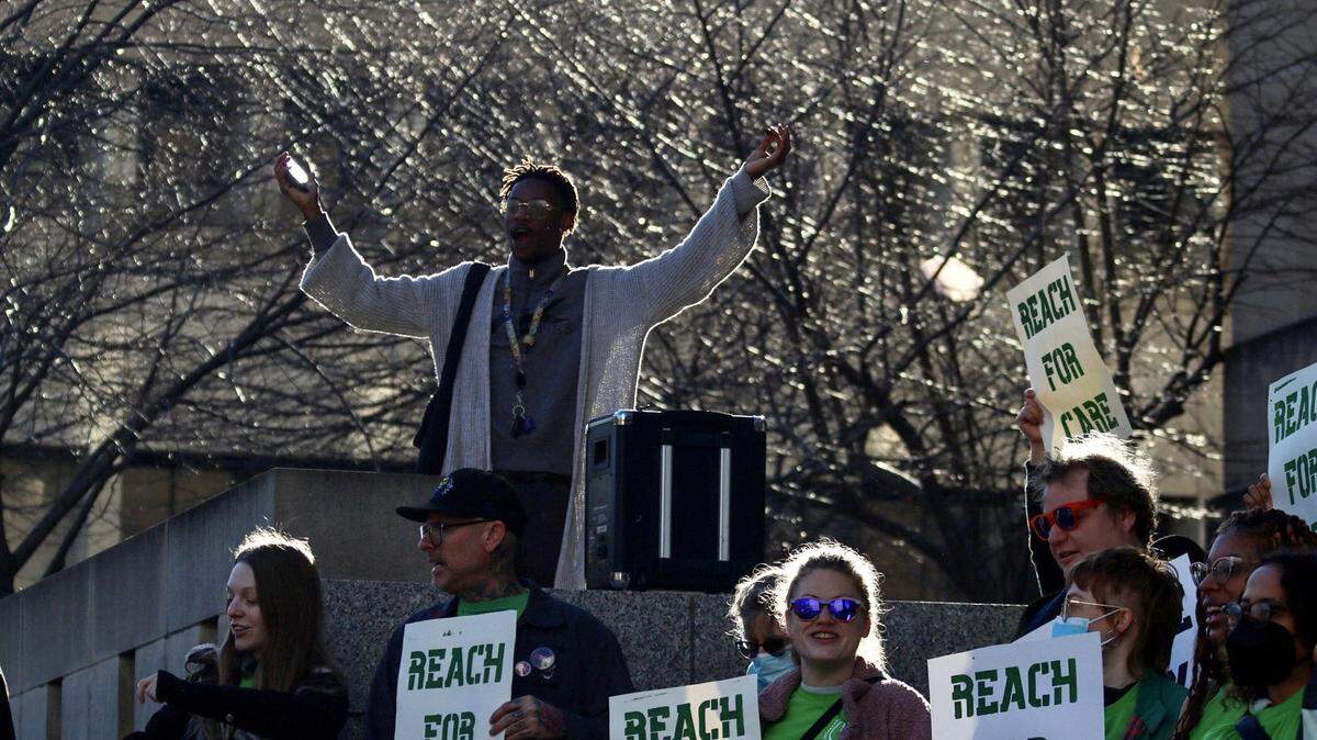 People hold signs and chant at the north entrance of Kansas City’s City Hall on March 2, 2024. A rally was held by Decarcerate KC to promote a REACH program that will be introduced to the City Council.