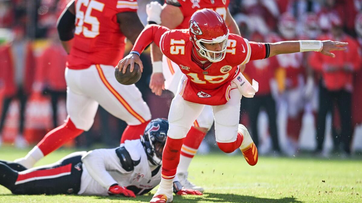 Kansas City Chiefs quarterback Patrick Mahomes (15) breaks free from the grasp of Houston Texans defensive tackle Tim Settle Jr. (98) to run in for a touchdown in the first quarter on Saturday Dec. 21, 2024, at GEHA Field at Arrowhead Stadium.