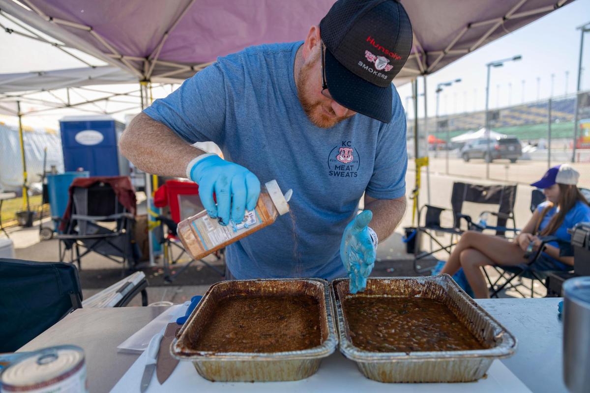 Jeremy Smith with team KC Meat Sweats seasons baked beans before turning them into judging at the American Royal World Series of Barbecue on Saturday, Oct. 1, 2022, in the infield of Kansas Speedway in Kansas City, Kan.