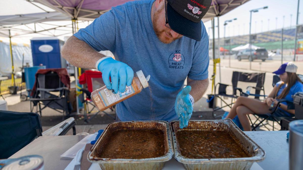 Jeremy Smith with team KC Meat Sweats seasoned baked beans before turning them into judging at the American Royal World Series of Barbecue in 2022 at the Kansas Speedway in Kansas City, Kan.