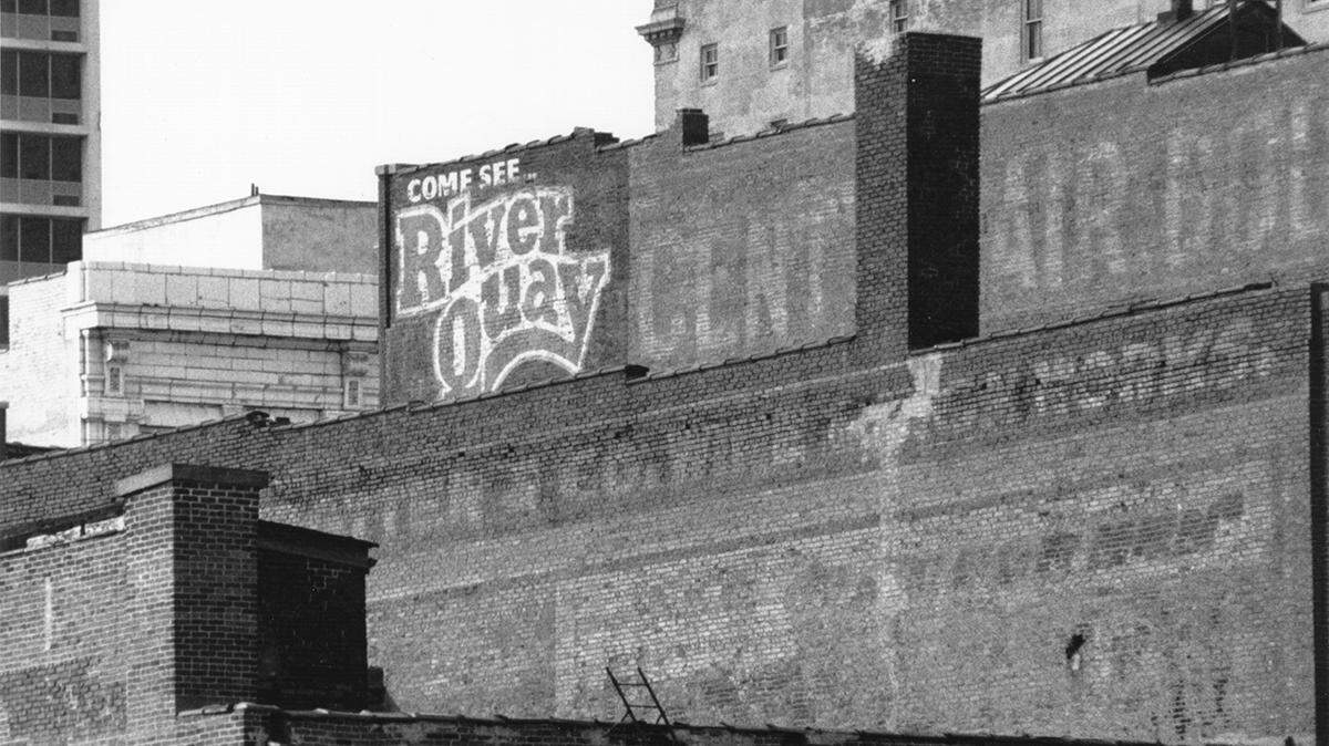 A weathered River Quay building sign near 13th and Main, 1991, from the General Photograph Collection (P1).