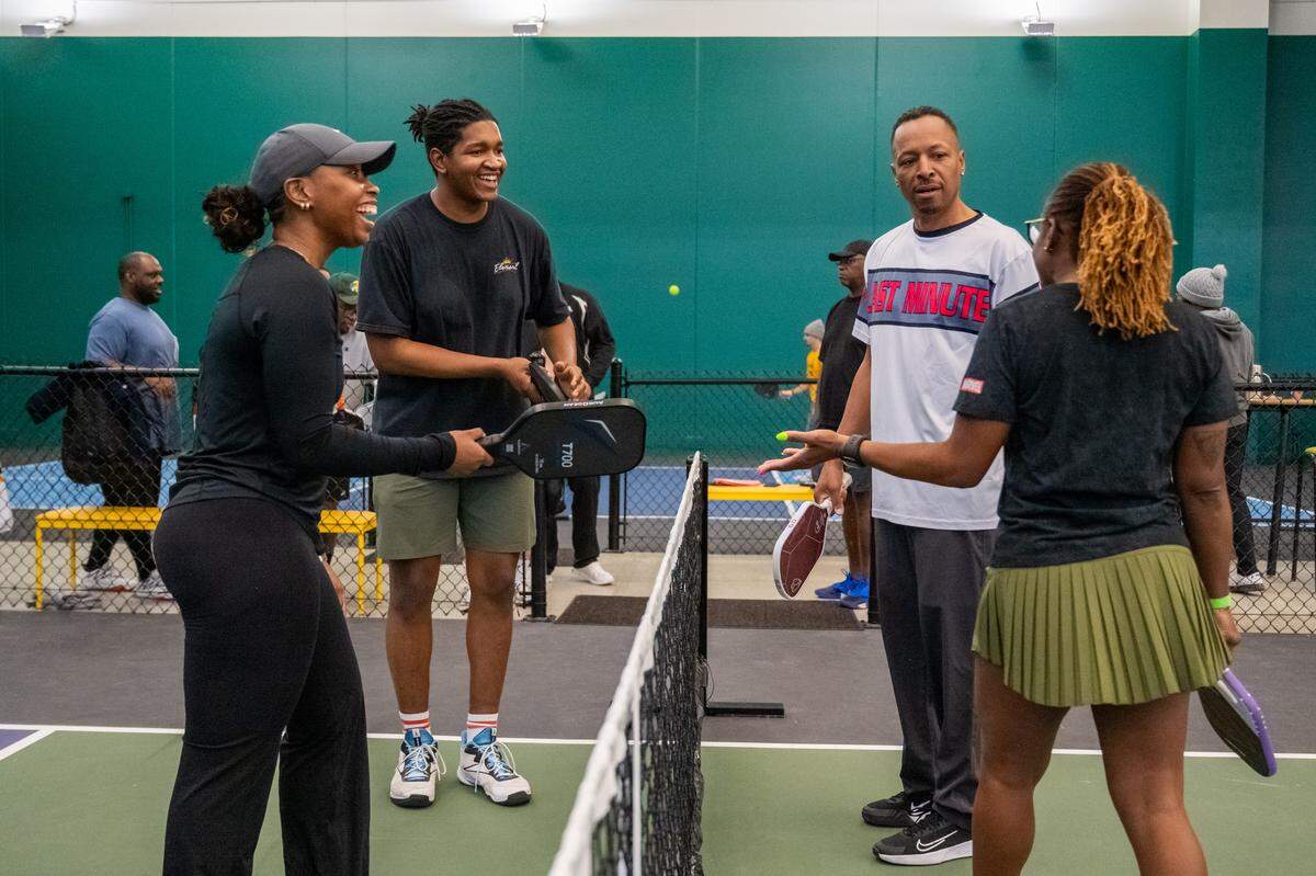 A group of players discuss the ending of a match during a meeting of the Black Pickleball Club at SW19 at the Stadium, on Sunday, Feb. 22, in Kansas City.