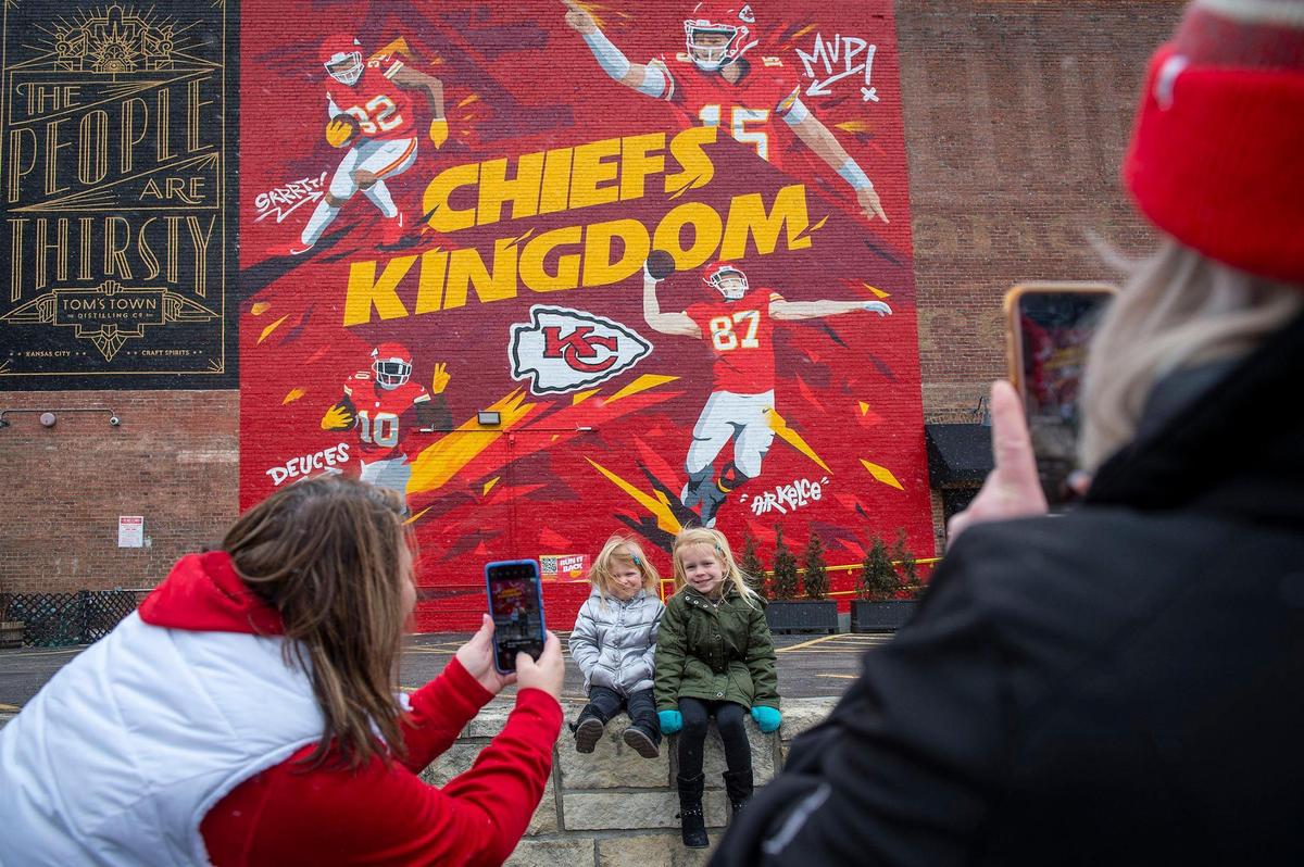 Stacey Robinson, left of Grain Valley, and Meagan Cruse braved the cold to take photos of Karsyn, 3, and Kinley Cruse, 4, with the Chiefs mural at 1701 Main St., painted by by artist Phil Shafer, aka Sike Style of Sike Style Industries.
