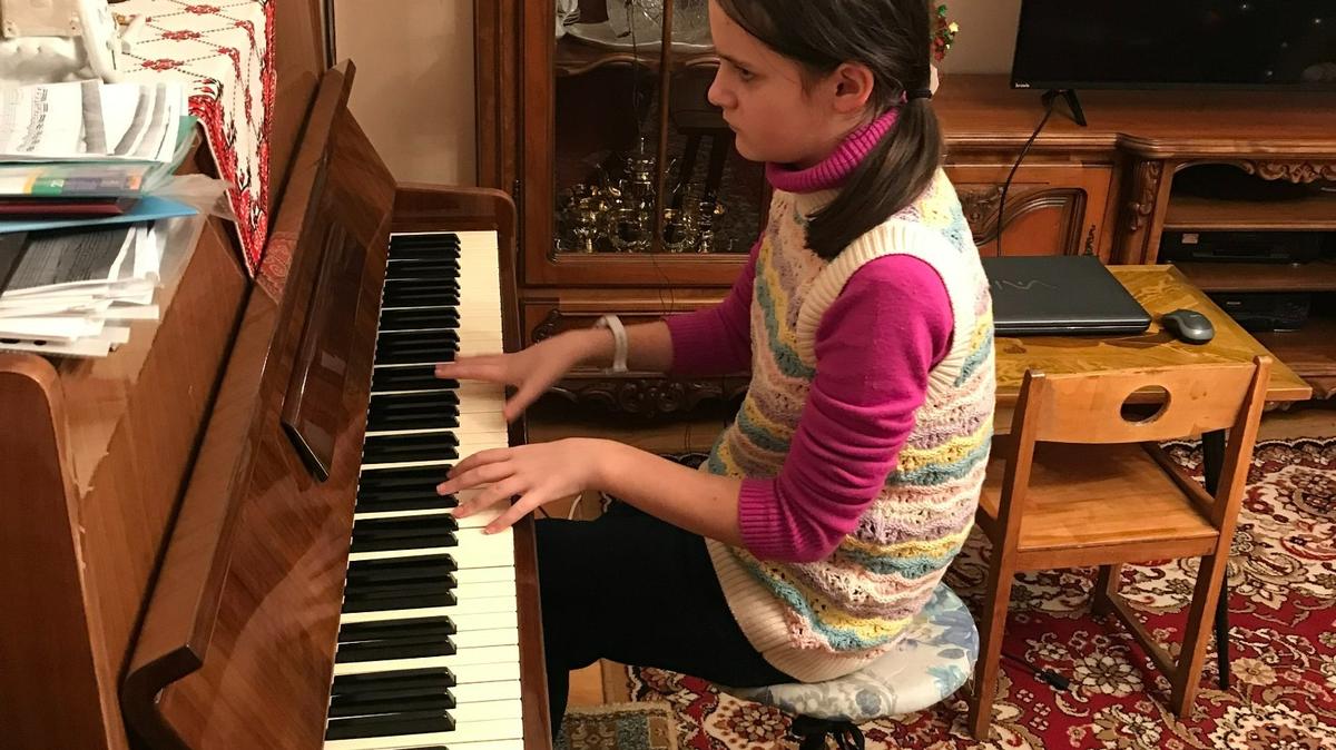 Solomia Beregovska, 12, plays piano at her grandparent’s home in Ivano-Frankivsk, a city in western Ukraine.