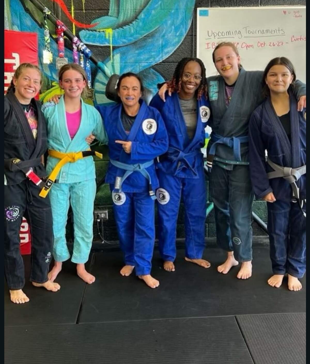 Ray’Von Haney and other female competitors pose for a photo in Jiu-jitsu uniforms.
