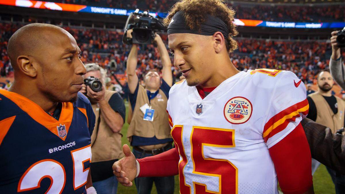 Kansas City Chiefs quarterback Patrick Mahomes (15) greets Denver Broncos cornerback Chris Harris Jr. (25) following a game at Broncos Stadium at Mile High in 2018.
