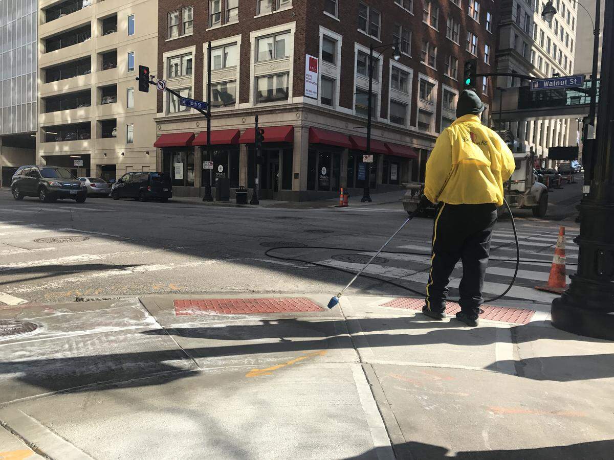 Downtown Community Improvement District employees cleaned the unlawful Jimmy John’s ads from intersections around the new Spokes Cafe & Cyclery on Thursday.
